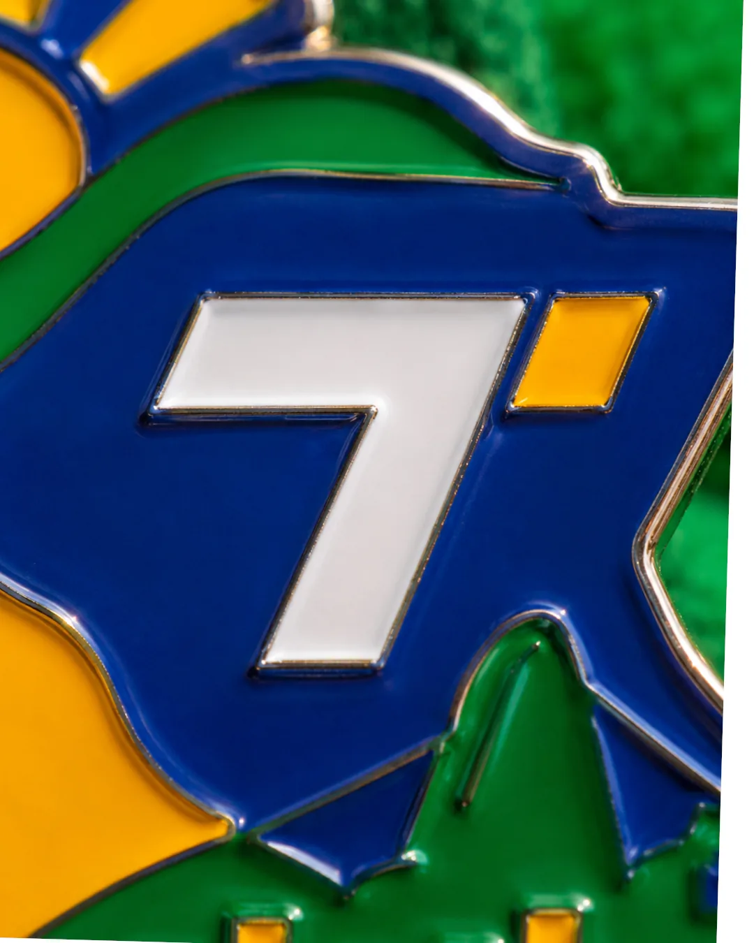 Enamel pin macro — hard enamel over metal, three-color fill